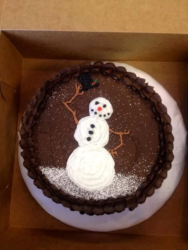 Round chocolate cake with a piped snowman on top