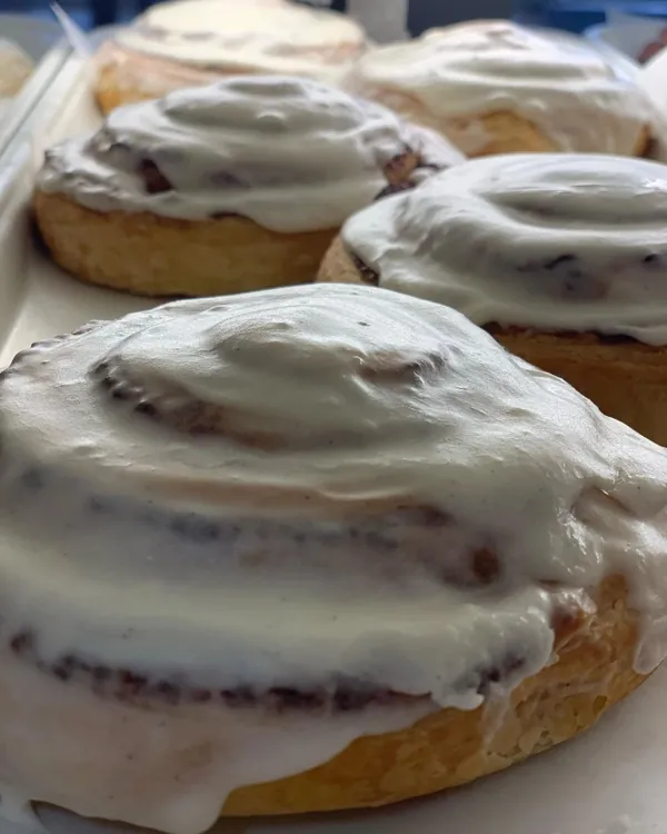 Cinnamon rolls with vanilla bean icing melting off the edge